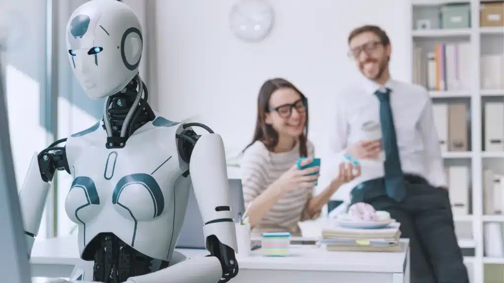 Robot sat a keyboard doing all the work whilst humans sit in the background on their phones