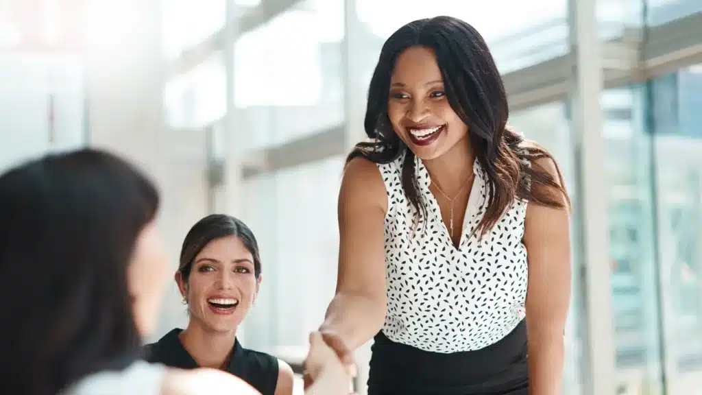 Business meeting between strategic partners shaking hands and smiling